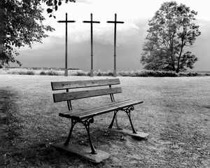 Three wooden crosses against a stormy sky. Black and white photo