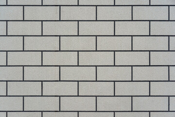 A clean, flat background texture of a modern grey brick wall with dark grout lines, laid in a classic running bond pattern.