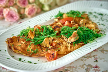 Deliciously Cooked Omelette Topped with Fresh Vegetables and Herbs Served Elegantly on a Platter Surrounded by Delicate Floral Accents