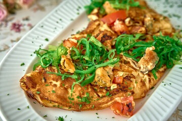 Delicious Savory Omelette Topped with Fresh Green Onions, Tomatoes, and Herbs on a Plate Ready to Delight Your Taste Buds at Any Meal