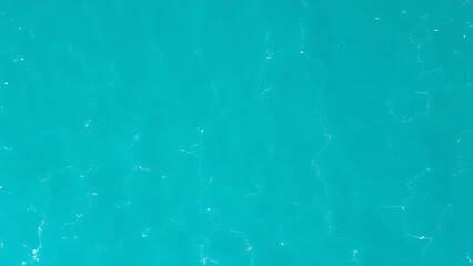 Aerial view of turquoise ocean waves forming abstract patterns, embodying a minimalist summer seascape.