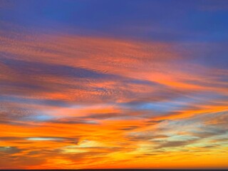 Fiery orange sunset sky clouds background. 