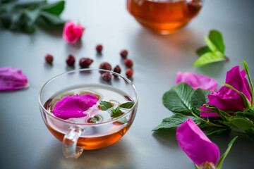 Herbal rosehip and mint tea in a cup and teapot from above