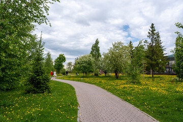 Walking paths made of paving slabs to UGMK Park in spring on cloudy day in town Verkhnyaya Pyshma....