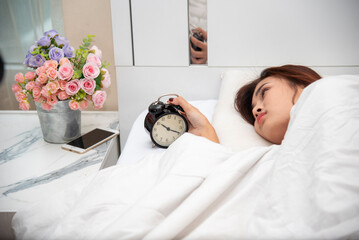 Asian women sleep wake up in white cozy bedroom happy time morning sunrise. Beautiful chinese use...