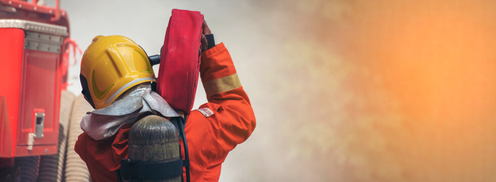 Banner Firefighter Rescue training fire fighting extinguisher. Firefighter fighting flame use fire hose chemical water foam spray engine. Banner Fireman wear hard hat, safety suit with copy space