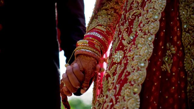 Traditional henna painted bridal hand. Red color is the traditional Indian clothes, Elements of hindu wedding. 