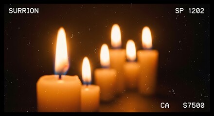 A row of lit candles glows warmly against a dark background, creating a peaceful and intimate ambiance.