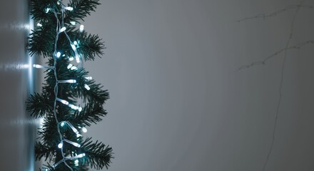 Illuminated Festive Garland with Twinkling White Lights against a Subdued Gray Background Signifying Holiday Decor and Minimalist Winter Ambiance