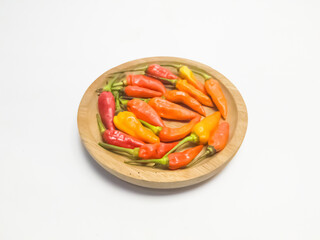 Red chili peppers in a wooden bowl isolated on a white background. Close up