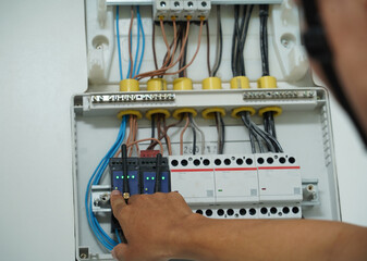 Electrician working checking a switchboard with fuses