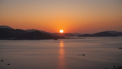 Obraz premium Beautiful evening sunset over the water, with orange and red clouds reflecting on the sea, river, or beach landscape