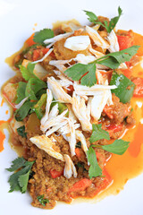 Stir-fried crab meat with curry powder decorates the top with steamed crab meat on white plate