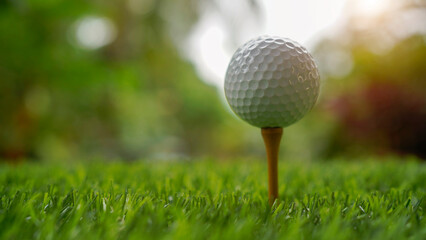 Golf ball on tee in beautiful golf course with sunset.