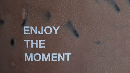 Close-up of a condensation-covered cup with the motivational phrase 