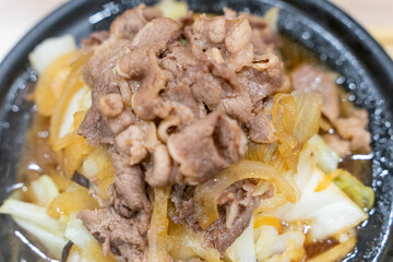 A traditional Asian clay pot rice dish is served piping hot, nestled in a rustic earthenware pot....