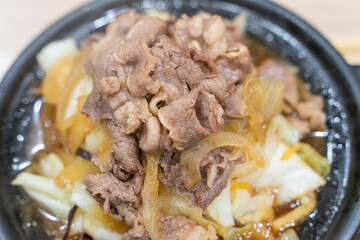 A traditional Asian clay pot rice dish is served piping hot, nestled in a rustic earthenware pot....