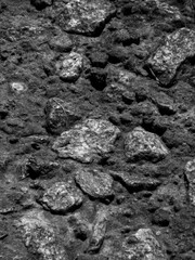 Monochrome Close-Up of Rough, Textured Ground with Embedded Rocks