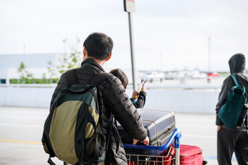 Passengers pushing luggage trolleys, waiting for taxis at the airport. Alaska. USA.