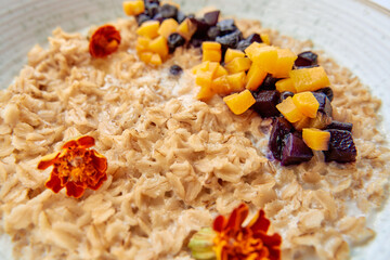 A Colorful Bowl of Oatmeal Topped with Fresh Fruit and Edible Flowers for a Nourishing Breakfast...