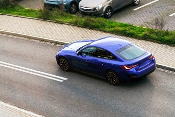 Blue sedan in motion on smooth city road