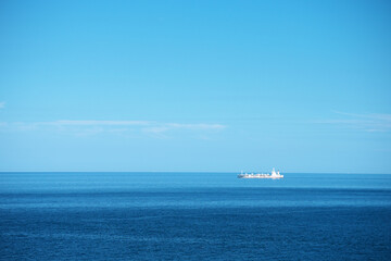 青色がきれいな夏の日本海と大型船
