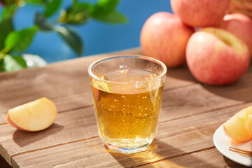 Sparkling Apple Cider in a Glass with Fresh Apples on a Wooden Table, Glass of apple juice on wooden table in garden, closeup view