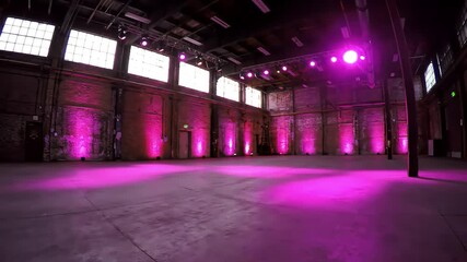 Pink-lit industrial warehouse event space