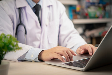 medical professional at a desk with a laptop, using modern technology to enhance productivity and...