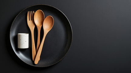 Wooden Cutlery Set on Elegant Black Plate with Minimalist Design and Modern Aesthetic