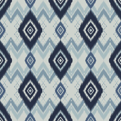 Seamless indigo ikat patterns in ethnic tribal style, featuring geometric diamond shapes and woven texture in blue tones.
