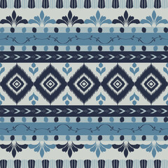 Seamless indigo ikat patterns in ethnic tribal style, featuring geometric diamond shapes and woven texture in blue tones.