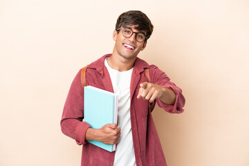 Young student caucasian man isolated on ocher background surprised and pointing front