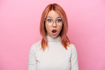 Young Russian girl isolated on pink background With glasses and surprised expression