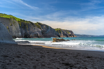 The cold Atlantic Ocean, the white foam of the waves and the golden sand of Zumaia beach