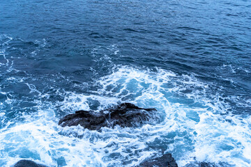 Fototapeta premium The cold Atlantic Ocean is surrounded by cinematic layered rocks that look like a dragon