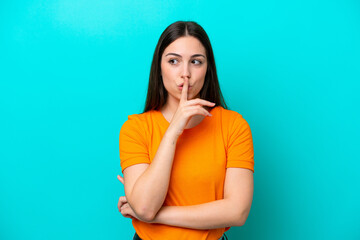 Young caucasian woman isolated on blue background showing a sign of silence gesture putting finger...