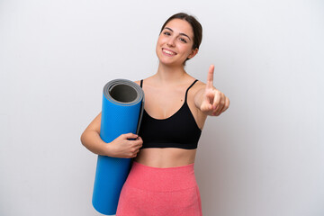 Young sport girl going to yoga classes while holding a mat isolated on white background showing and...