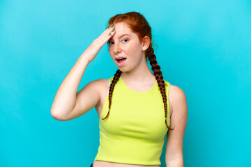 Young reddish woman isolated on blue background has realized something and intending the solution