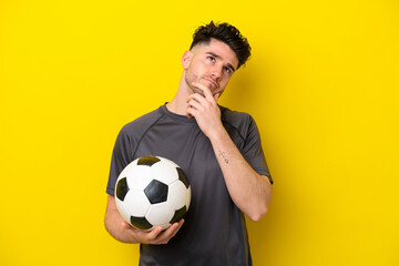 Handsome young football player man isolated on yellow background having doubts