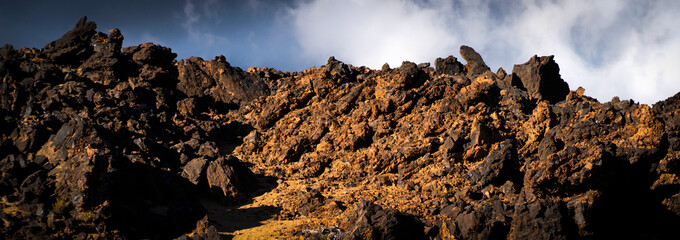 A moon landscape with lava formations, volcanic mountains, volcanoes and desert at sunset.