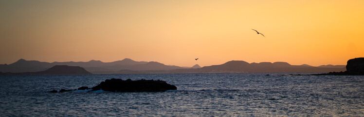 A small island in the beautiful ocean with small waves in the evening  at sunset.