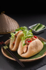 Food concept Homemade organic chicken Bao Buns or Gua Bao in bamboo stream tray on black background with copy space