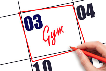 3rd day of the month. Hand writing Gym reminder and drawing red frame on calendar with red pen on...