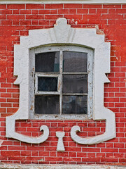 An old white window in a red brick wall