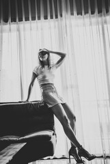Sexy nude young woman with black mask posing near the sofa