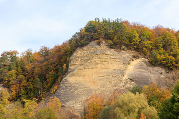 Beautiful colorful autumn landscape of the hills with trees, rocks and green lawns in countryside