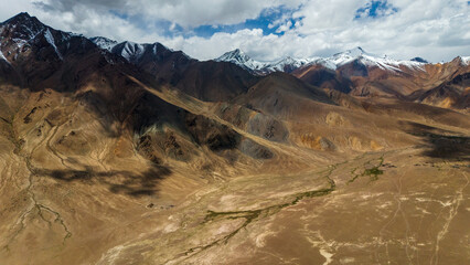 Aerial view of the Pamir Highway winding through the dramatic mountain landscapes of Tajikistan's Gorno-Badakhshan region breathtaking views of the Pamir Mountains  Central Asia's legendary Silk Road 