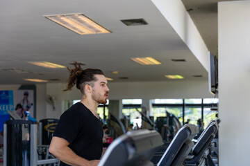 Smart fitness trainer shows how to use treadmill to improve leg strength and building muscles in a gym. A sport man is running on a treadmill to start his workout program.