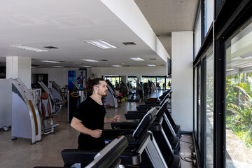 Smart fitness trainer shows how to use treadmill to improve leg strength and building muscles in a gym. A sport man is running on a treadmill to start his workout program.